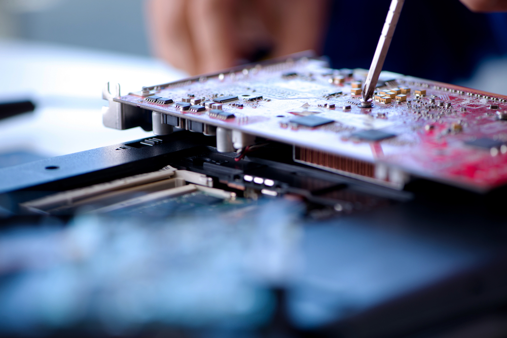 A close-up photo of a screwdriver adjusting something in a computer chip